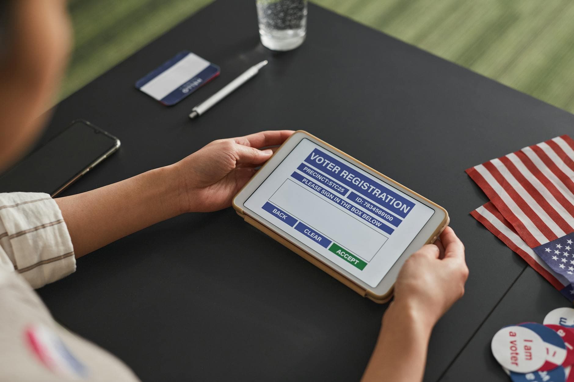 A person using a tablet for voter registration, highlighting digital voting processes.