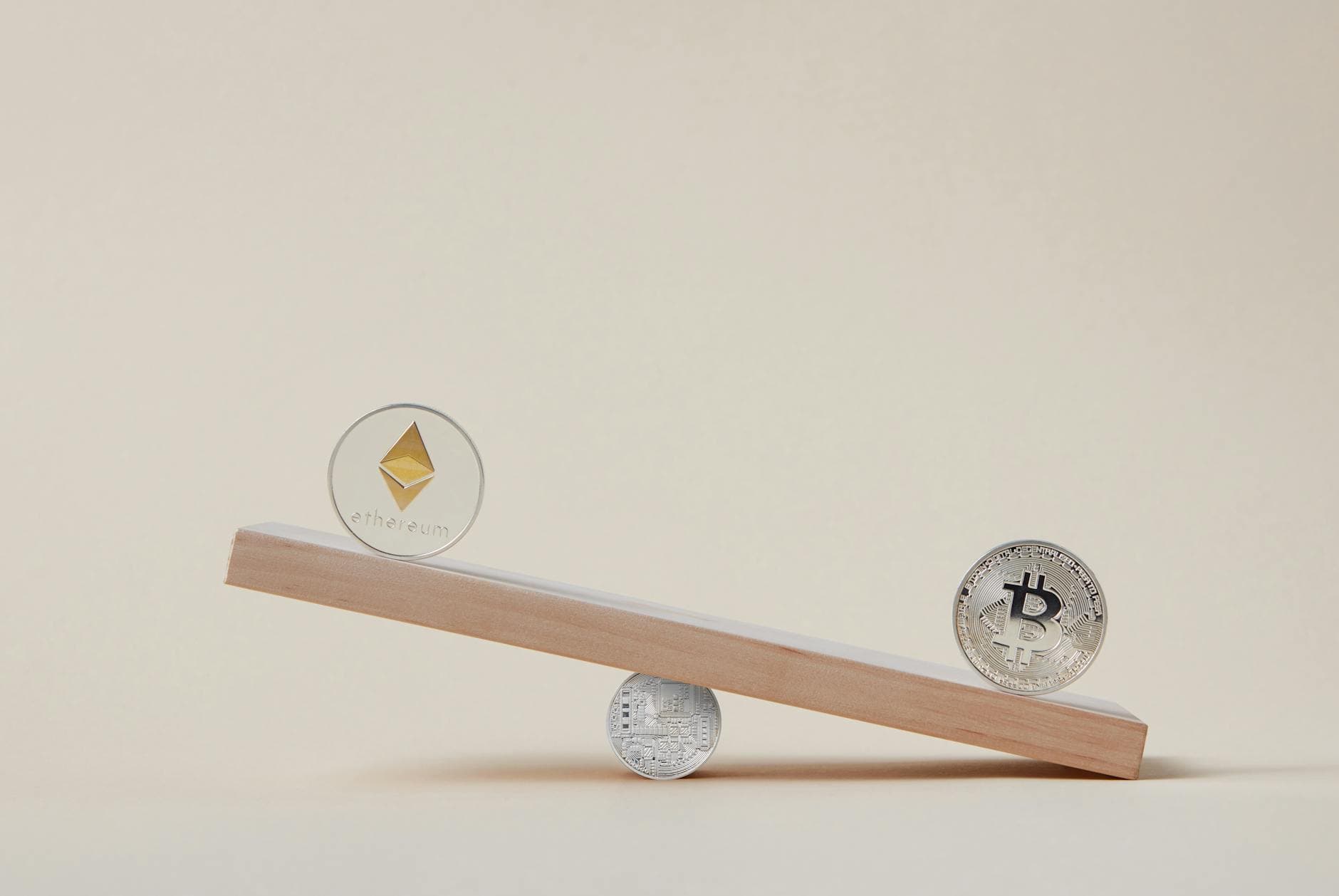Minimalist image of Ethereum and Bitcoin coins balancing on a plank, symbolizing crypto market dynamics.