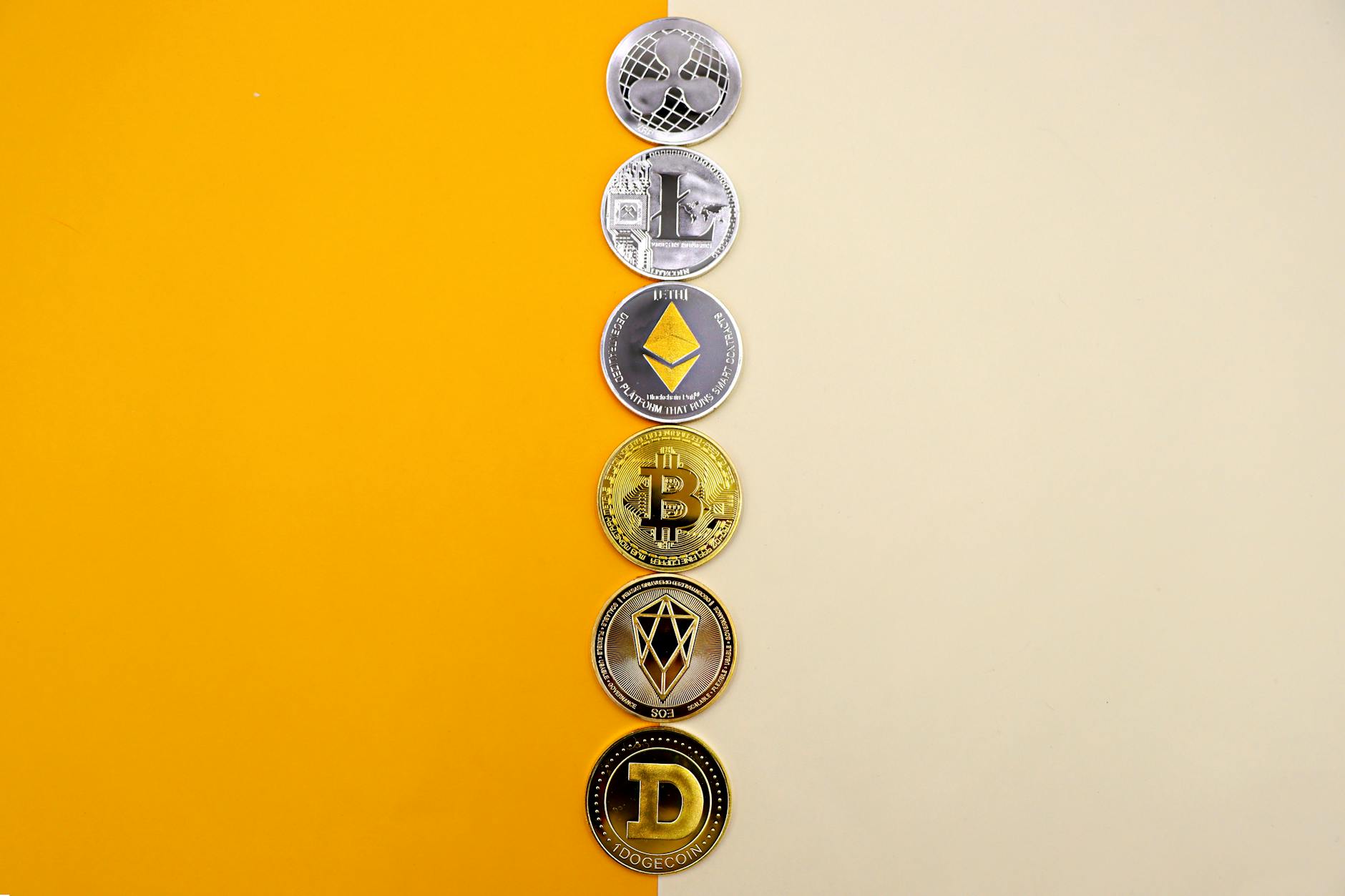 A row of cryptocurrency coins including Bitcoin, Ethereum, and Dogecoin on a vibrant yellow surface.